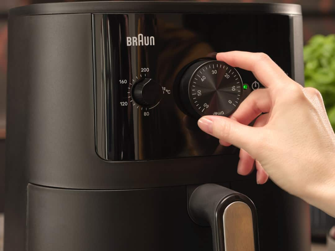 Female hand setting temperature on Brauns MultiFry 3 airfryer