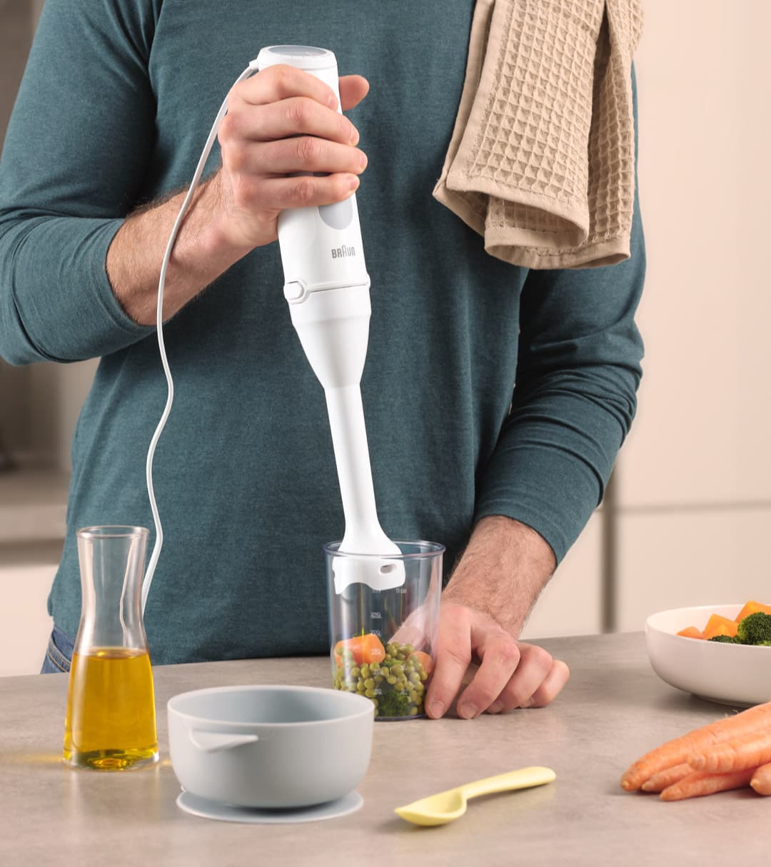 A man prepares a pea and carrot puree with a Braun MQ 5 Hand blender with the small portion shaft.