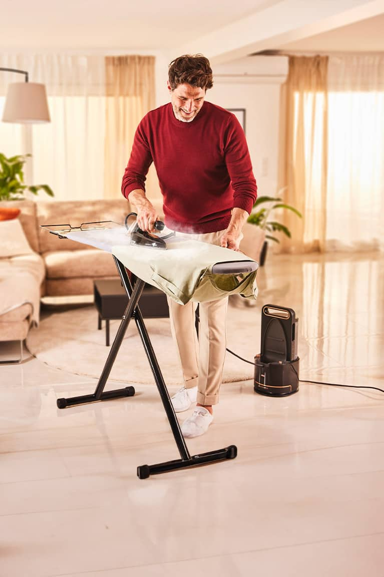 Man irons a shirt with Braun CareStyle 9 steam generator iron