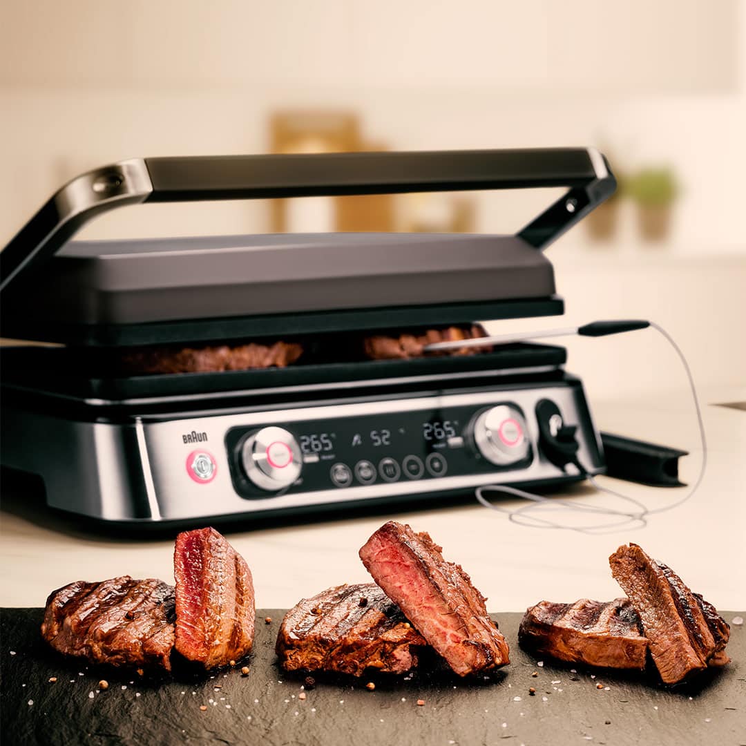 MultiGrill 9 Pro and a pan filled with various meats, showcasing a delicious cooking scene.