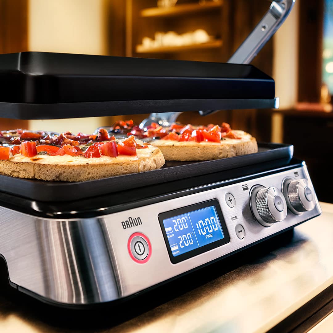 MultiGrill 9 featuring two pizzas cooking on its surface